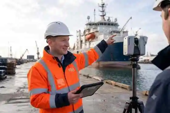 ISCA surveyor using a 3D laser scanner beside a commercial vessel